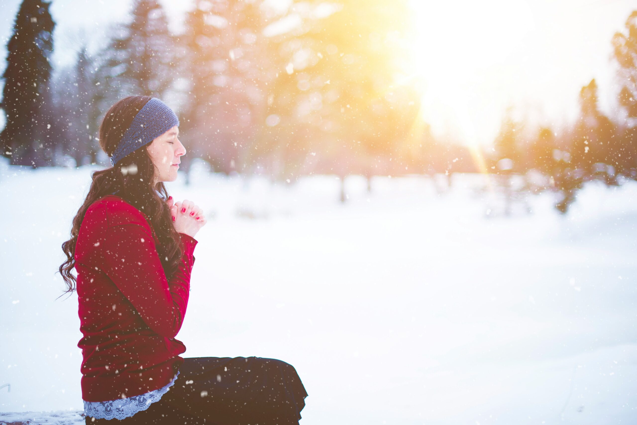meditation in winter fundraising idea A woman meditates in the snow as the sun sets